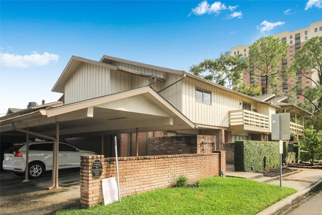 view of front facade featuring brick siding, board and batten siding, and covered parking