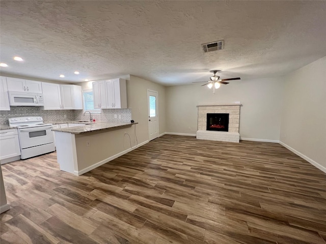 1705 Westwind Dr, Brenham, TX 77833 - kitchen with white appliances, white cabinets, dark wood-style flooring, recessed lighting, and ceiling fan