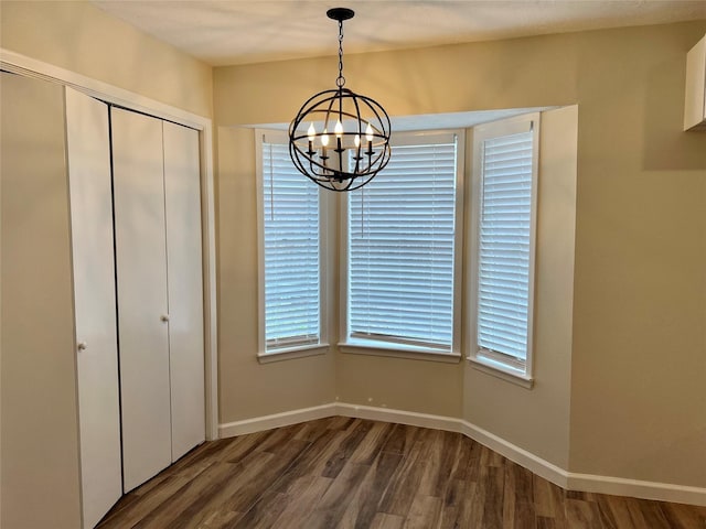 1705 Westwind Dr, Brenham, TX 77833 - unfurnished dining area featuring dark wood finished floors, a chandelier, plenty of natural light, and baseboards