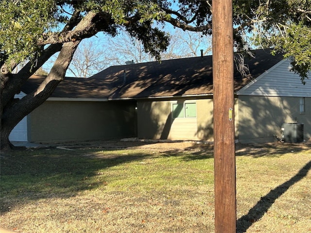 1705 Westwind Dr, Brenham, TX 77833 - back of property featuring central AC, a lawn, and brick siding