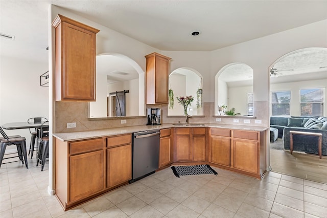13602 Kodiak Brown Bear St, Crosby, TX 77532 - kitchen with stainless steel dishwasher, light countertops, backsplash, and brown cabinetry