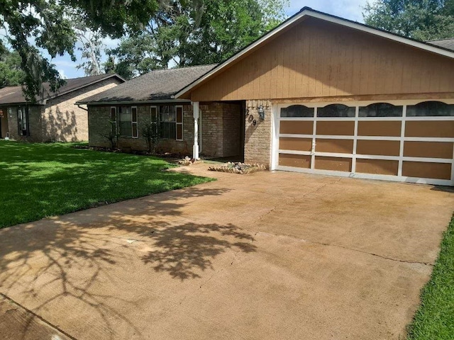 209 Montclaire Dr, West Columbia, TX 77486 - ranch-style house with a garage, driveway, a front lawn, and brick siding