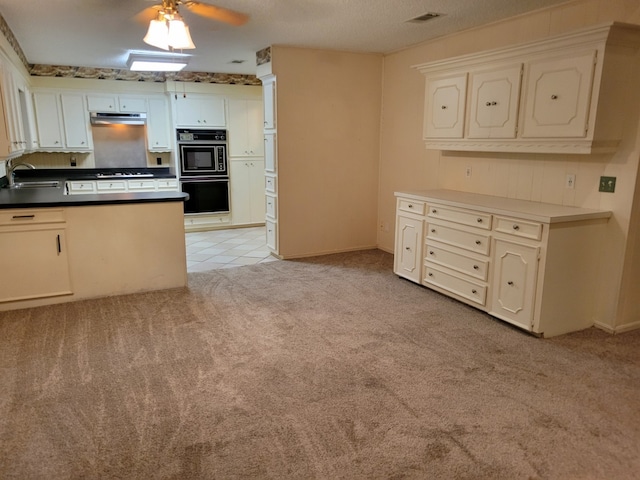 209 Montclaire Dr, West Columbia, TX 77486 - kitchen with light carpet, black appliances, a peninsula, under cabinet range hood, and dark countertops