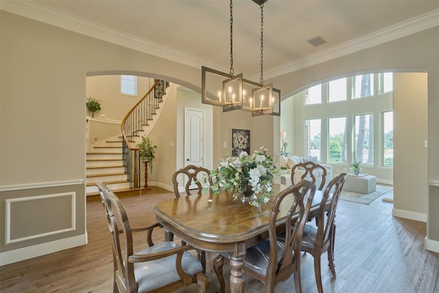 13606 Oak Harbor Bnd, Cypress, TX 77429 - dining space with ornamental molding, arched walkways, baseboards, a chandelier, and stairs