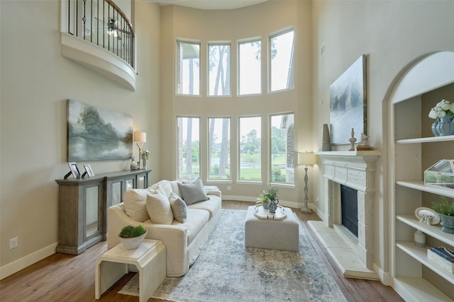 13606 Oak Harbor Bnd, Cypress, TX 77429 - living room with a high ceiling, a fireplace, plenty of natural light, wood finished floors, and baseboards