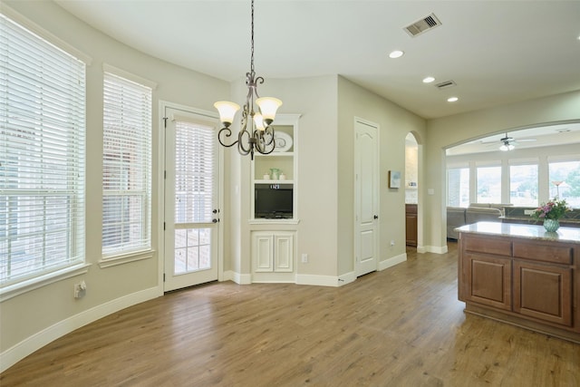 13606 Oak Harbor Bnd, Cypress, TX 77429 - kitchen featuring arched walkways, wood finished floors, a ceiling fan, a chandelier, and recessed lighting