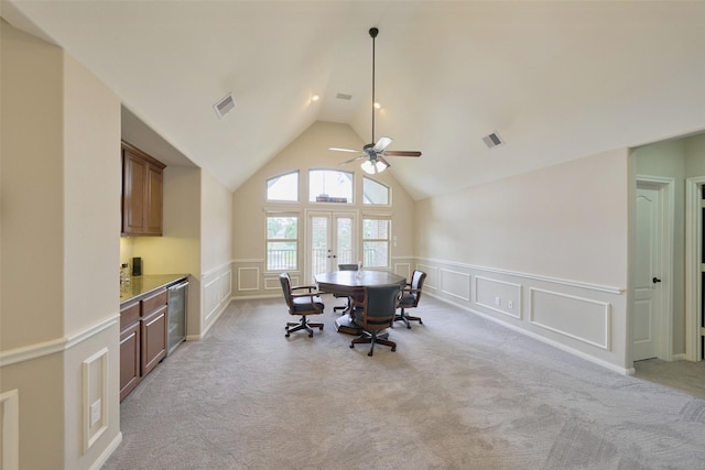 13606 Oak Harbor Bnd, Cypress, TX 77429 - dining area featuring a decorative wall, ceiling fan, light colored carpet, vaulted ceiling, and wainscoting