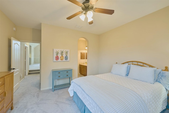 13606 Oak Harbor Bnd, Cypress, TX 77429 - bedroom with light carpet, arched walkways, baseboards, a ceiling fan, and connected bathroom