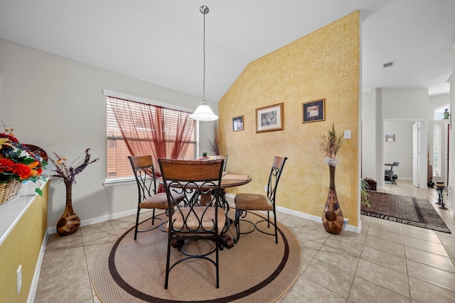 dining area with vaulted ceiling, baseboards, and light tile patterned flooring