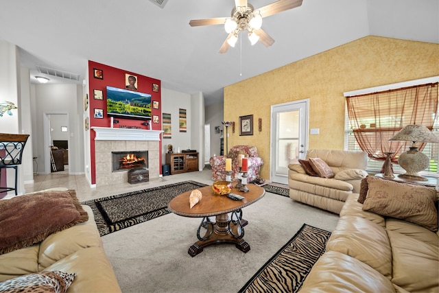 living room with a ceiling fan, a tile fireplace, and lofted ceiling