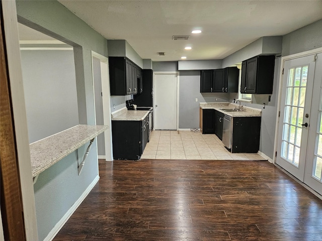 111 Carnation St, Lake Jackson, TX 77566 - kitchen featuring dark cabinets, a sink, light wood-type flooring, light countertops, and recessed lighting