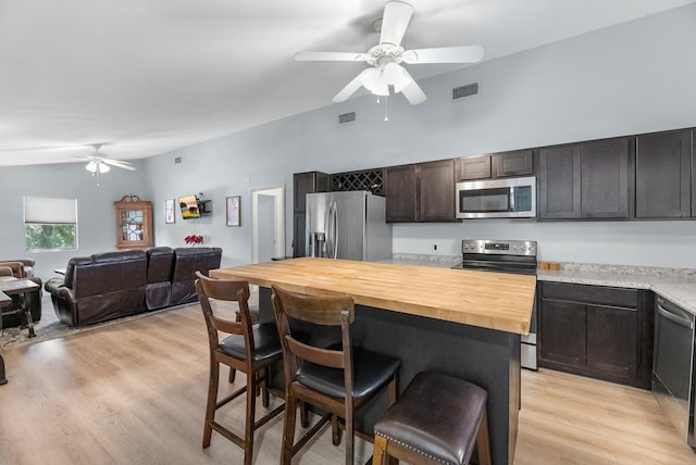 518 Marine Way, Freeport, TX 77541 - kitchen featuring stainless steel appliances, a ceiling fan, a breakfast bar area, wooden counters, and a kitchen island
