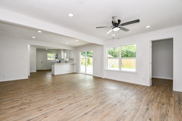 1915 Springrock Ln, Houston, TX 77080 - unfurnished living room featuring light wood-style floors, ceiling fan, baseboards, and recessed lighting