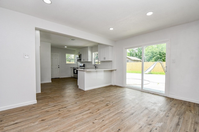 1915 Springrock Ln, Houston, TX 77080 - kitchen with appliances with stainless steel finishes, light countertops, light wood-type flooring, baseboards, and recessed lighting
