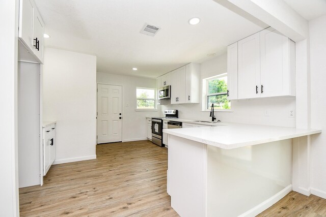 1915 Springrock Ln, Houston, TX 77080 - kitchen featuring appliances with stainless steel finishes, a sink, baseboards, light wood finished floors, and recessed lighting