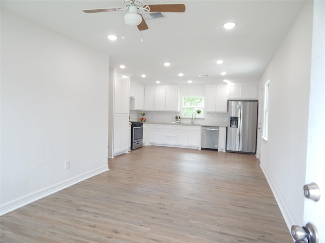 846 Magnolia St, Lake Jackson, TX 77566 - kitchen with stainless steel appliances, a ceiling fan, light wood-type flooring, white cabinetry, and light countertops