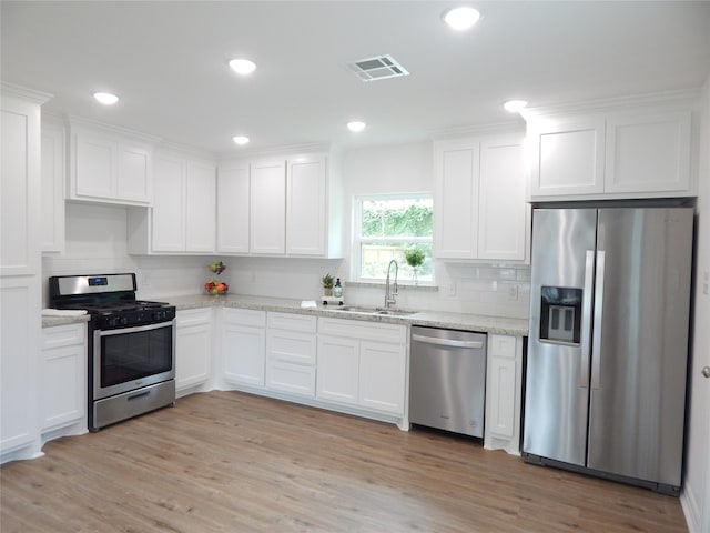 846 Magnolia St, Lake Jackson, TX 77566 - kitchen with stainless steel appliances, white cabinetry, light wood finished floors, and recessed lighting