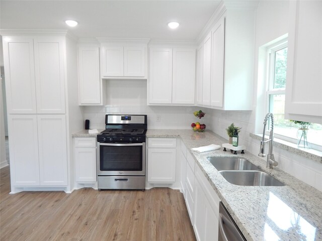 846 Magnolia St, Lake Jackson, TX 77566 - kitchen featuring appliances with stainless steel finishes, a sink, white cabinetry, and tasteful backsplash