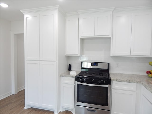 846 Magnolia St, Lake Jackson, TX 77566 - kitchen featuring stainless steel gas range oven, tasteful backsplash, white cabinets, and light wood-style floors
