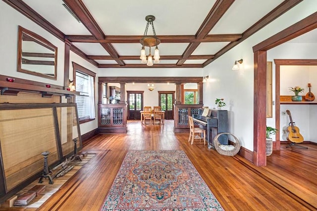 605 Sue St, Houston, TX 77009 - living area featuring wood finished floors, a chandelier, baseboards, beam ceiling, and coffered ceiling