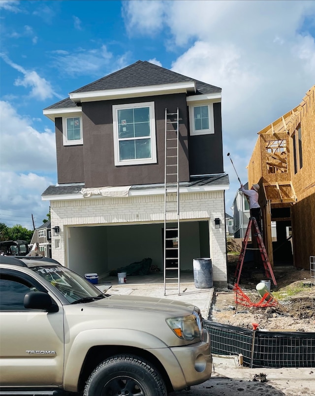2805 E Park Hl, Stafford, TX 77477 - view of front facade featuring a shingled roof, stucco siding, brick siding, and an attached garage