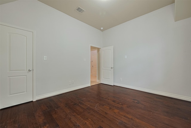 empty room with dark wood finished floors and baseboards