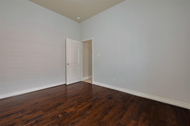 unfurnished room with dark wood-style floors and baseboards