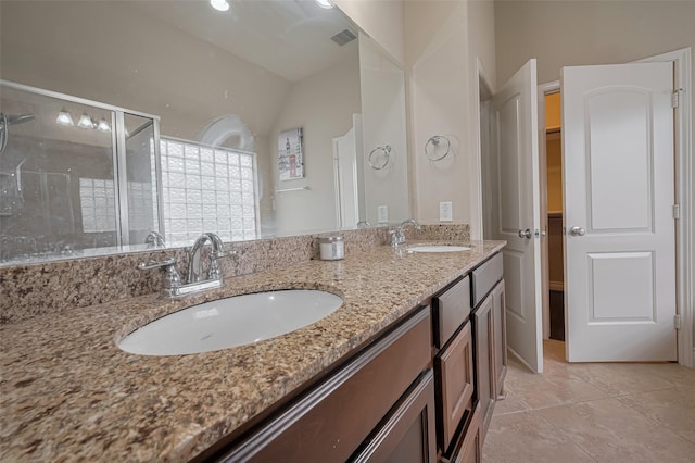 bathroom with a stall shower, double vanity, tile patterned flooring, and vaulted ceiling