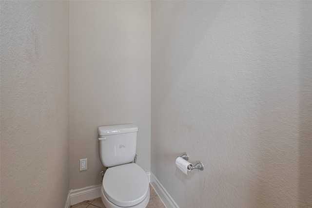 bathroom with tile patterned floors, toilet, and baseboards