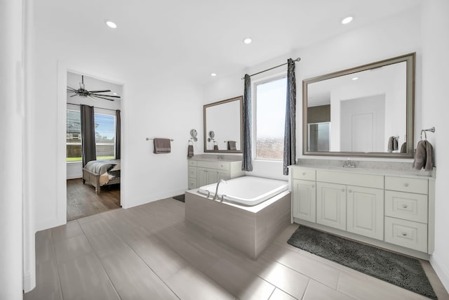 1827 Woodtrace Blvd, Pinehurst, TX 77362 - bathroom featuring recessed lighting, a bath, baseboards, connected bathroom, and two vanities