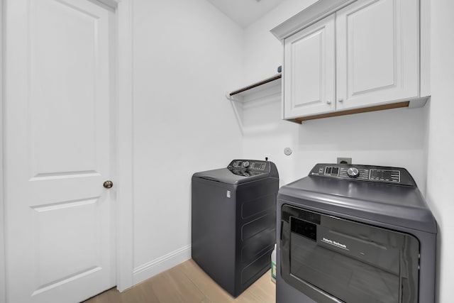 1827 Woodtrace Blvd, Pinehurst, TX 77362 - laundry area with cabinet space, independent washer and dryer, light wood-type flooring, and baseboards