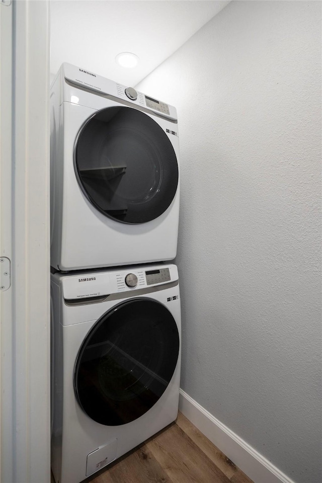3814 Seabrook St, Houston, TX 77021 - laundry room with stacked washer and clothes dryer, wood finished floors, and baseboards