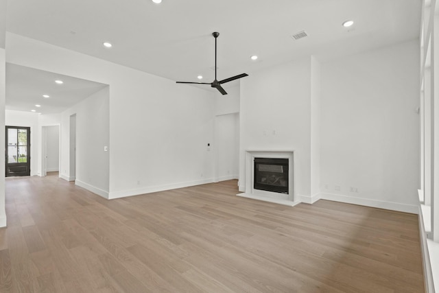 1827 Chantilly Ln, Houston, TX 77018 - unfurnished living room with recessed lighting, light wood-type flooring, a glass covered fireplace, ceiling fan, and baseboards