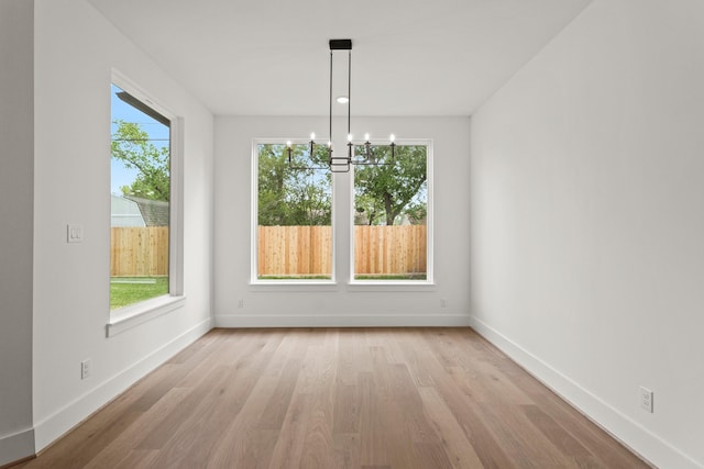 1827 Chantilly Ln, Houston, TX 77018 - unfurnished dining area with a chandelier, light wood-style floors, and baseboards