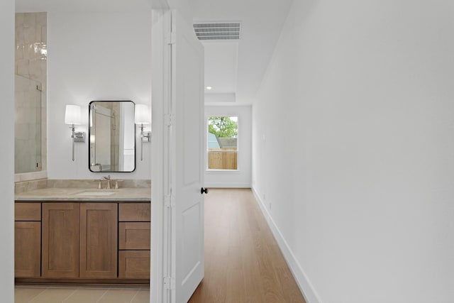1827 Chantilly Ln, Houston, TX 77018 - bathroom with vanity, a tile shower, baseboards, and wood finished floors