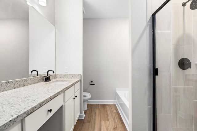 910 Whispering Winds Dr, Beasley, TX 77417 - full bathroom featuring toilet, a shower stall, wood finished floors, vanity, and a tub to relax in