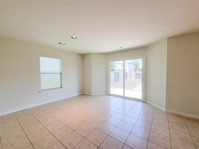 26118 Flinton Dr, Richmond, TX 77406 - empty room with light tile patterned floors, a textured ceiling, and baseboards