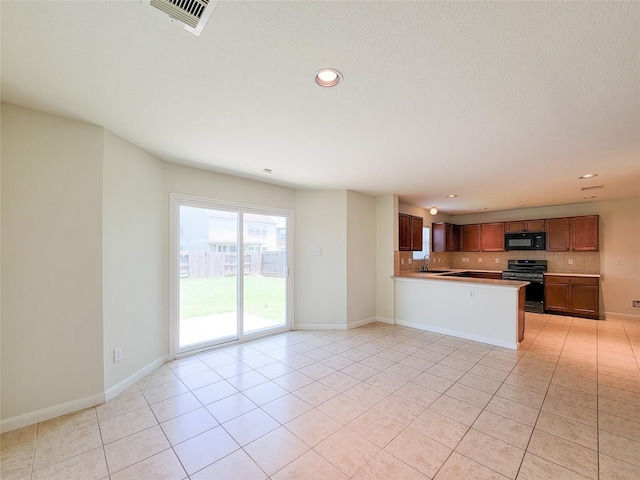 26118 Flinton Dr, Richmond, TX 77406 - kitchen featuring gas stove, black microwave, decorative backsplash, light tile patterned floors, and recessed lighting