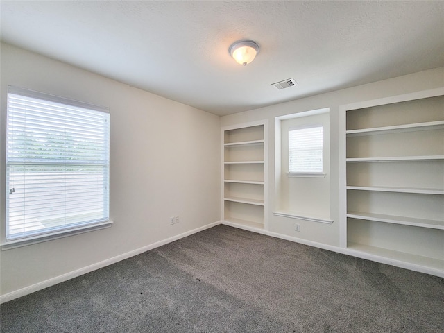 26118 Flinton Dr, Richmond, TX 77406 - unfurnished room featuring baseboards, dark colored carpet, and healthy amount of natural light