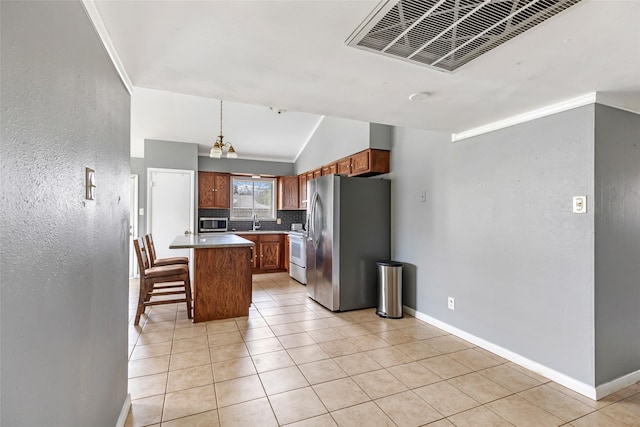 7730 Wickersham Pl, Beaumont, TX 77706 - kitchen featuring appliances with stainless steel finishes, a breakfast bar area, brown cabinets, baseboards, and backsplash