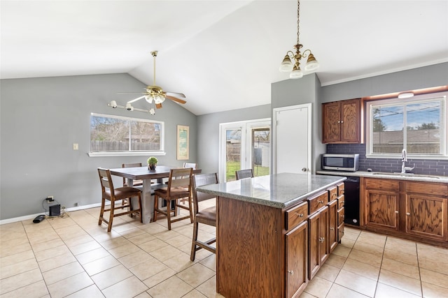 7730 Wickersham Pl, Beaumont, TX 77706 - kitchen featuring a sink, stainless steel microwave, light tile patterned flooring, black dishwasher, and a chandelier