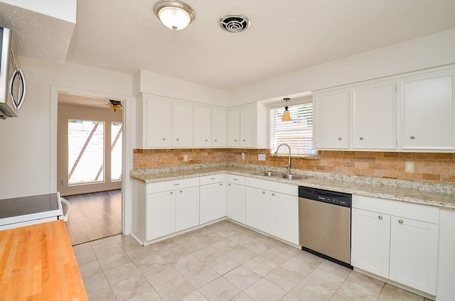 kitchen with appliances with stainless steel finishes, a sink, backsplash, and plenty of natural light