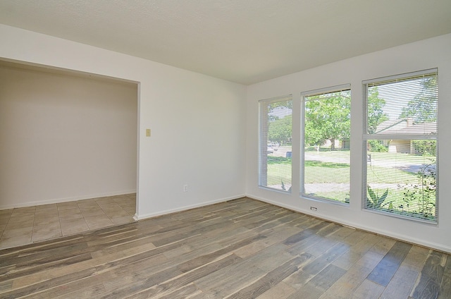 spare room with wood finished floors and baseboards