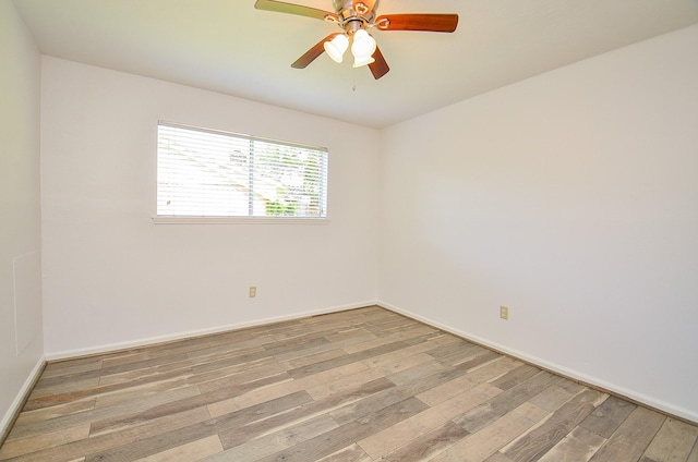spare room with light wood-type flooring, ceiling fan, and baseboards