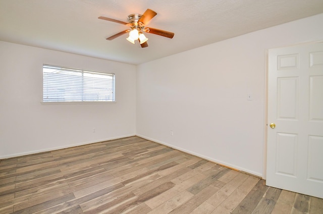 empty room with ceiling fan and light wood-style flooring