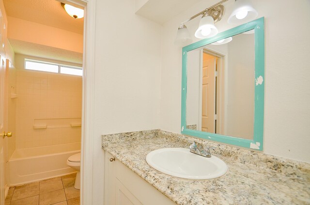 bathroom featuring toilet, tile patterned floors, vanity, and shower / bathtub combination