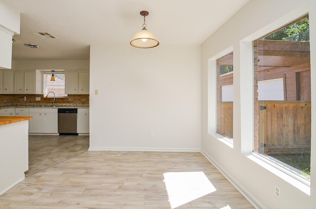 unfurnished dining area featuring baseboards and light wood-style flooring