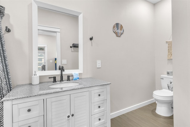 1079 Cedar Ln, Gilchrist, TX 77617 - half bathroom with toilet, wood finished floors, vanity, and baseboards