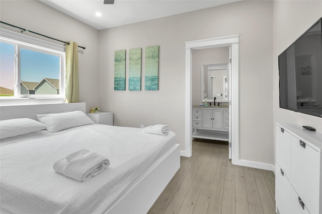 1079 Cedar Ln, Gilchrist, TX 77617 - bedroom featuring light wood-type flooring, ensuite bath, a sink, baseboards, and recessed lighting