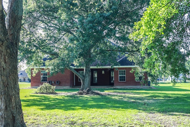 5468 Hogaboom Rd, Groves, TX 77619 - view of property hidden behind natural elements featuring a front lawn and brick siding